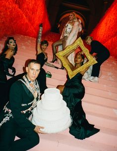 a man kneeling down next to a white cake on top of a set of stairs