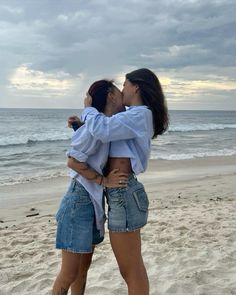 two women hugging each other on the beach