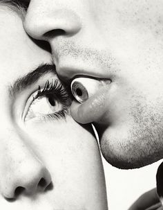 a man and woman kissing each other with their noses close to one another's cheek