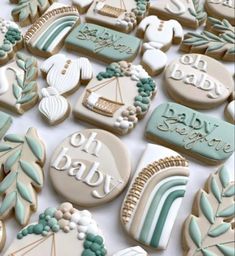 many decorated cookies on a white table with words and designs in blue, green and gold