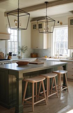 a kitchen island with three stools in front of it