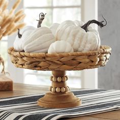 some white pumpkins in a basket on a table