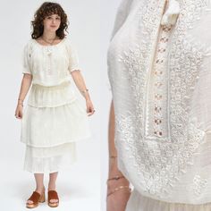 DESCRIPTION Exquisite 1960's Embroidered Cream Gauze Bohemian Peasant Dress This is a Rare Beauty with the Most Divine Embroidery!  Pull Over the Head Construction with a Rounded Wide Delicately Smocked Neckline with Drawstring for Gathered Fit. Blouson Top with an Intricate Embroidered and Floral Lace Centre Front Panel and Floral Embroidery on Front and Back. Soft Double Elastic Waist with Belt Loops and Pretty Puffed Short Sleeves with Embroidered Florals and Delicate Smocked Band. Three Tier Bohemian Embroidered Peasant Top For Daywear, Head Construction, Three Tiered Skirt, Blouson Top, Crochet Lace Trim, Rare Beauty, Three Tier, Peasant Dress, Dress Clothes For Women