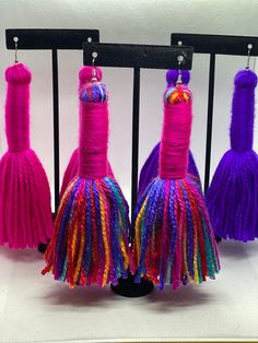 three colorful tassels are hanging on a rack