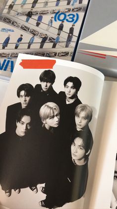 an open book with black and white photos on it's cover, showing the band members