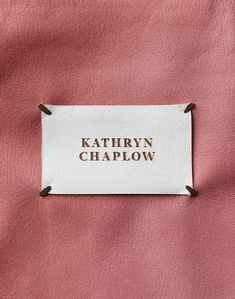 a label that says, kathyn chaplow on the side of a pink jacket