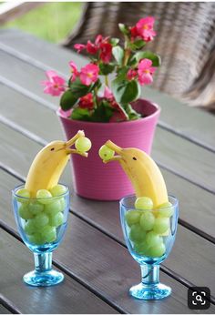 two glasses with grapes and bananas in them