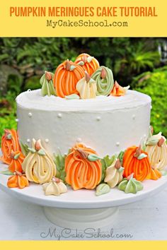 a white cake with pumpkins and leaves on it