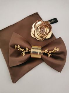 Taupe Boutonniere, Brown Bow Suit And Tie Accessories For Party, Dapper Brown Suit And Tie Accessories For Wedding, Elegant Brown Bow Tie, Elegant Brown Bow Tie For Formal Occasions, Brown Satin Bow Tie For Party, Elegant Brown Bow For Party, Dapper Brown Bow Tie For Wedding, Dapper Brown Bow Tie For Party