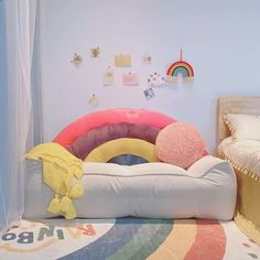 there is a bed with pillows on it and a rainbow rug in the room next to it