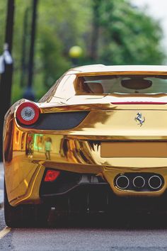 the rear end of a gold colored sports car