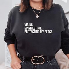 You can't get more powerful than Vibing & Manifesting Sweatshirt. The printed design is a reminder to show your intentions, but also how you feel. Manifestation T Shirt, Vinyl Sweatshirt Ideas Cricut, Sweatshirt Sayings, Sweatshirt Quotes, Cricut Clothes, Gym Tshirt, Protect Your Peace, Night Out Tops, Relaxing At Home