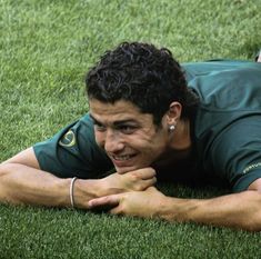 a man laying on the grass with his hand under his chin