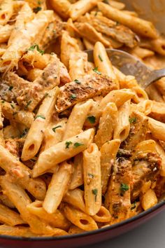 a bowl full of pasta with meat and parmesan cheese on top, ready to be eaten