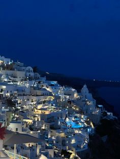 the city is lit up at night with white buildings and lights on it's sides