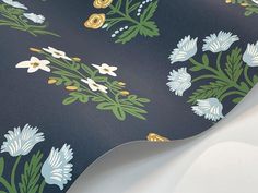 a blue and green wallpaper with white flowers on it's back side,