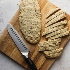 a cutting board topped with sliced bread next to a knife