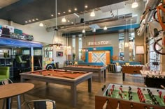 an indoor recreation room with pool tables, foo - pong tables and other games