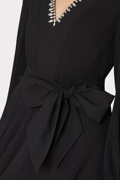 This black pleated mini dress features a slim peasant sleeve, a v-neckline, a pleated skirt, and a tie at the waist for added shape. It works so well for both day and night. This season’s take features a cocktail party-ready crystal embellished neckline. Peasant Sleeve, Embellished Neckline, Pleated Mini Dress, Cocktail Evening Dresses, Maxi Dress Cocktail, Swimsuit Cover Ups, Day And Night, Sweater And Shorts, Pleated Dress