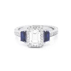 an emerald and blue sapphire ring with diamonds on the sides, set in 18k white gold