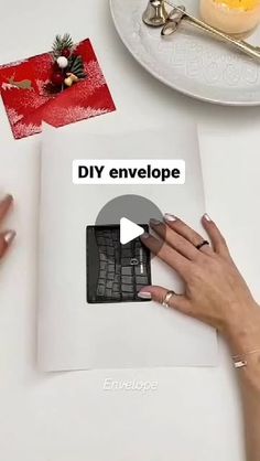 a woman's hands on top of a book with the words diy envelope