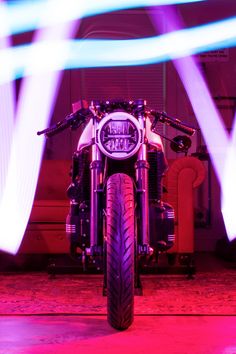 a motorcycle parked in front of a red and blue light with its lights on it