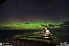 an image of the aurora bore in the night sky over a ship docked at sea