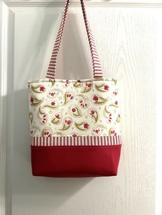 a red and white bag hanging on a door handle next to a white door with striped handles