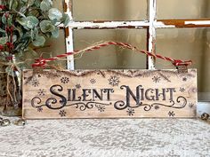 a wooden sign sitting on top of a table next to a vase filled with flowers