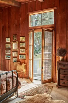 a bedroom with wood paneling and pictures on the walls, along with a bed