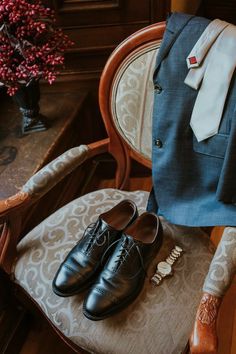 a suit and tie sitting on top of a chair next to a pair of shoes