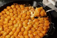 a skillet filled with tater tots on top of a table