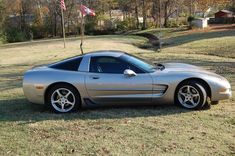 a silver sports car parked in the grass