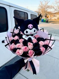 a bouquet of pink and black roses in front of a white truck with a stuffed animal