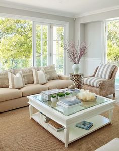 a living room filled with furniture and a large window covered in lots of natural light