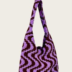 a purple and black handbag hanging from a hook