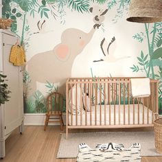 a baby's room decorated in green and white with an elephant mural on the wall