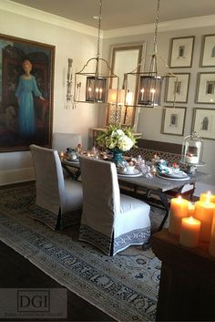 the dining room table is set with candles and pictures on the wall behind it,