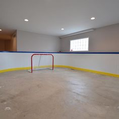 an empty hockey rink with a goal in the middle and no one around it on the other side