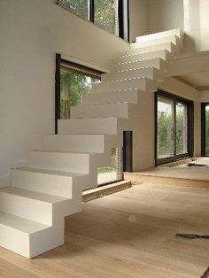 an empty room with stairs leading up to the second floor and windows on both sides