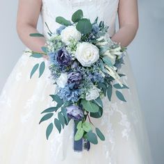 a bride holding a bouquet of white and blue flowers