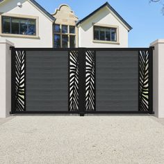 a modern gate is shown in front of a large white house with black and brown accents