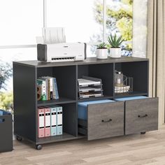 a computer desk with two drawers and a printer on the top shelf next to it