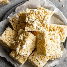 rice krispy treats stacked on top of each other in a paper plate with parchment paper