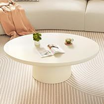 a white couch sitting next to a table on top of a rug