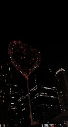 a large heart shaped object in the middle of a city at night