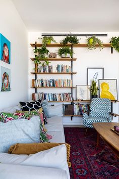 a living room filled with lots of furniture and bookshelves full of books on shelves