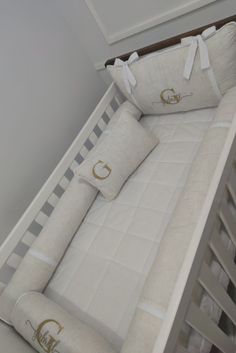 a baby crib with two pillows on top of it and a pillow in the middle