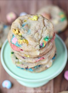 a stack of cookies with sprinkles on a plate next to other cookies