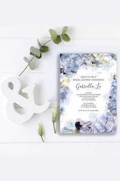 a white and blue wedding card with flowers on it